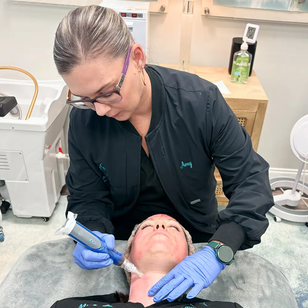 Amy Mounce, licensed aesthetician, performing procedure on patient