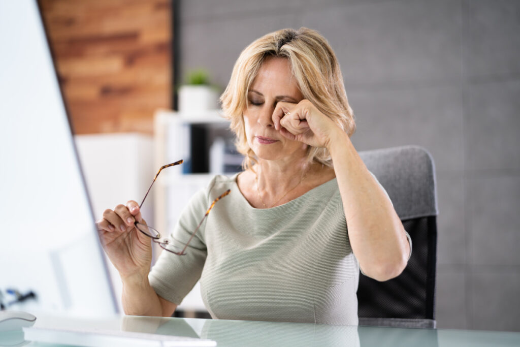 Woman working at desk with dry, irritated eyes